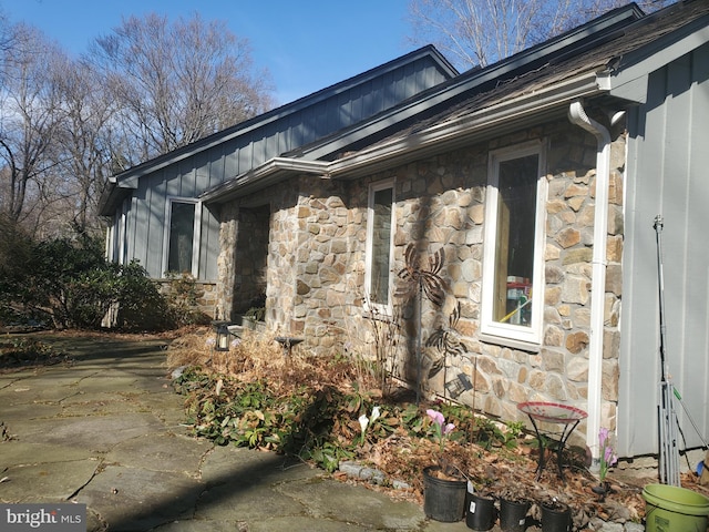 view of side of home featuring stone siding and board and batten siding