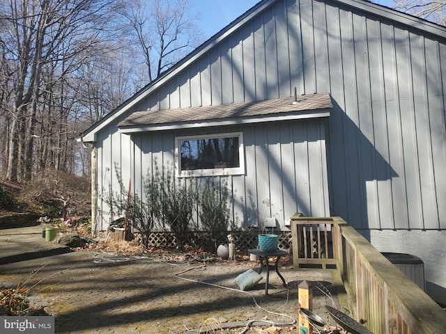 view of home's exterior featuring central AC, a shingled roof, and board and batten siding