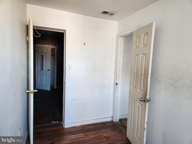 unfurnished bedroom featuring visible vents and wood finished floors