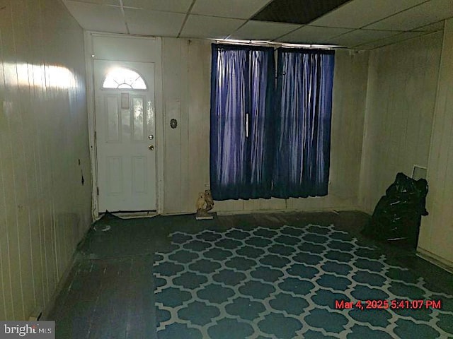 entryway featuring a paneled ceiling and wooden walls