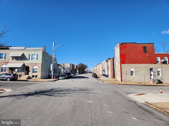 view of road with curbs, street lighting, sidewalks, and a residential view