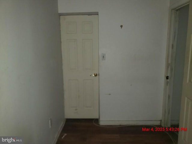 hallway featuring baseboards and wood finished floors