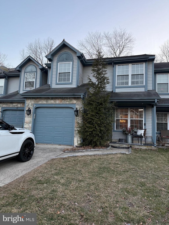 view of front of property featuring a front lawn, driveway, stone siding, covered porch, and a garage