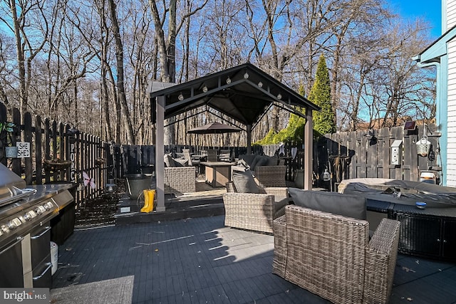 deck with a gazebo, outdoor lounge area, and a fenced backyard