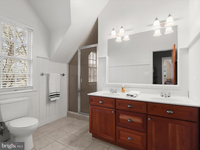 bathroom featuring a sink, double vanity, a stall shower, and vaulted ceiling