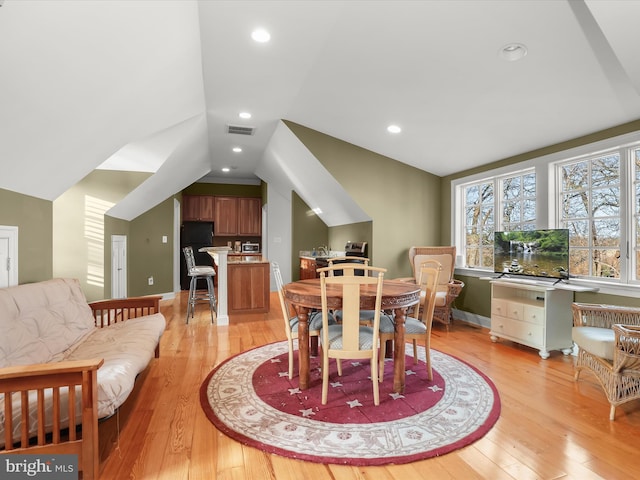dining area with light wood-style floors, recessed lighting, visible vents, and lofted ceiling