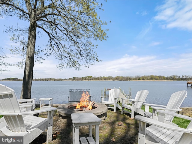view of dock with a water view and a fire pit