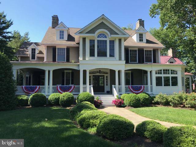 view of front of property featuring a front yard, a porch, and a chimney