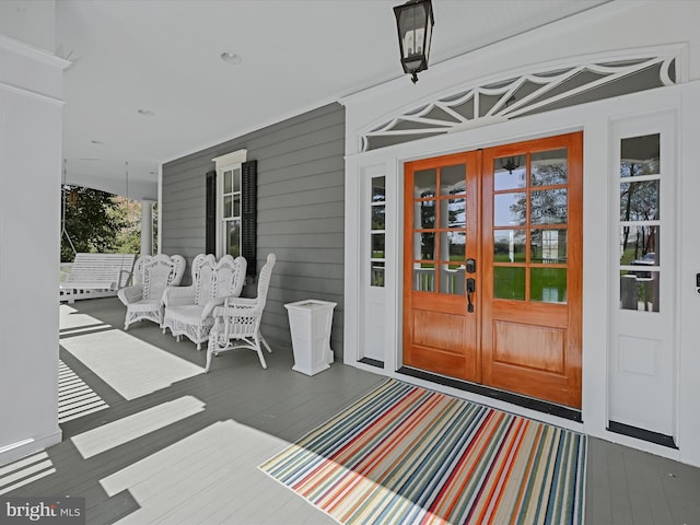 doorway to property with a porch and french doors