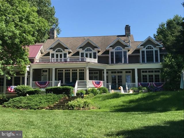 rear view of property featuring a lawn