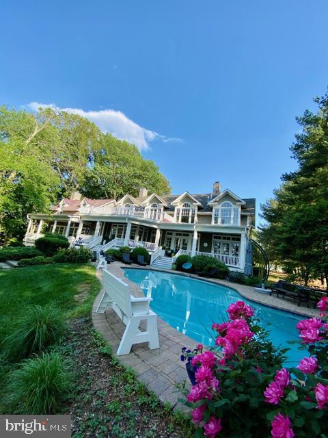 pool with a patio and a lawn