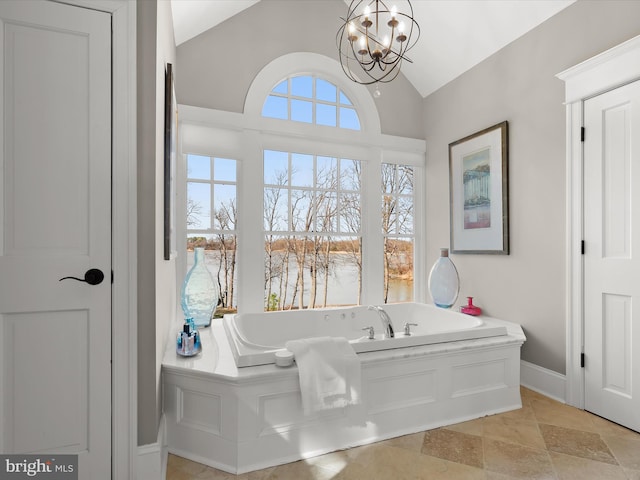 bathroom with a chandelier, a bath, baseboards, and lofted ceiling