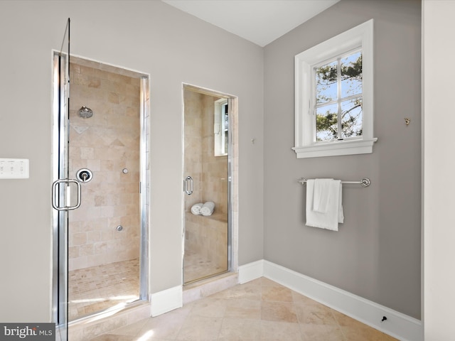 bathroom with a shower stall and baseboards