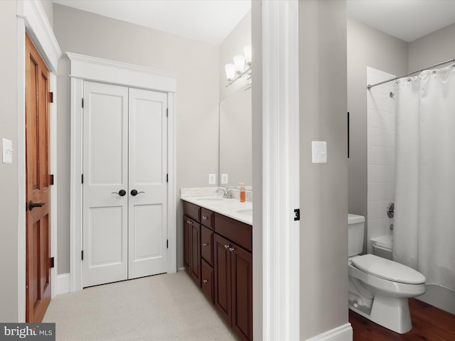 bathroom with a sink, toilet, and double vanity