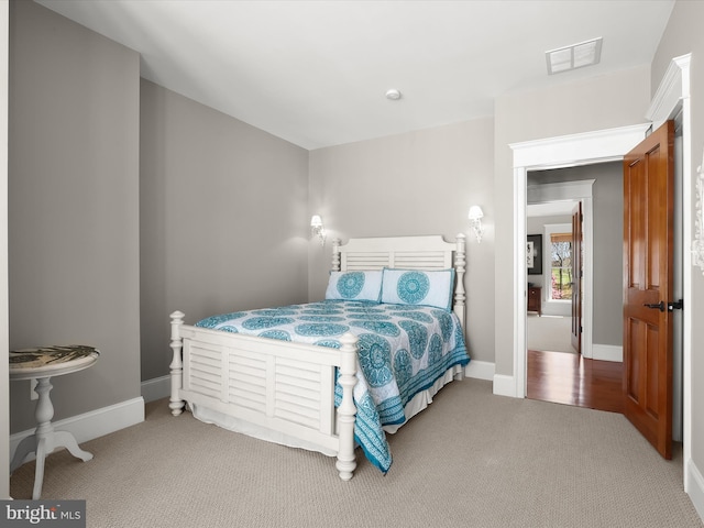 carpeted bedroom featuring visible vents and baseboards