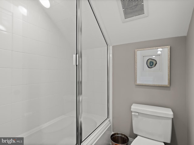 bathroom with visible vents, toilet, shower / bath combination with glass door, and lofted ceiling