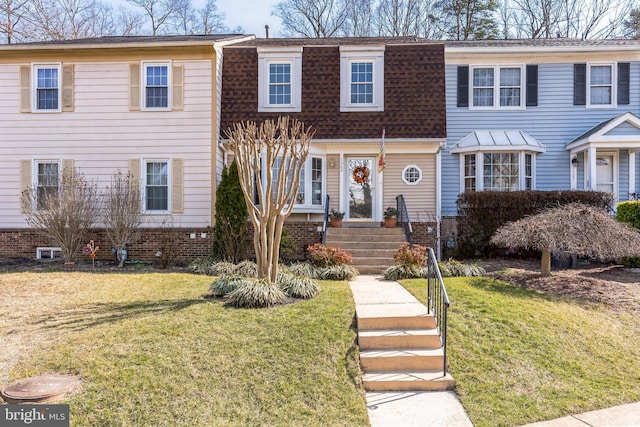 multi unit property featuring a shingled roof and a front lawn