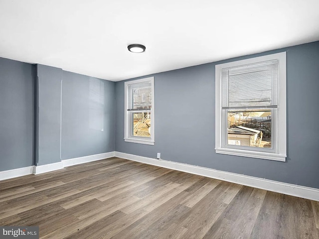 empty room featuring baseboards and wood finished floors