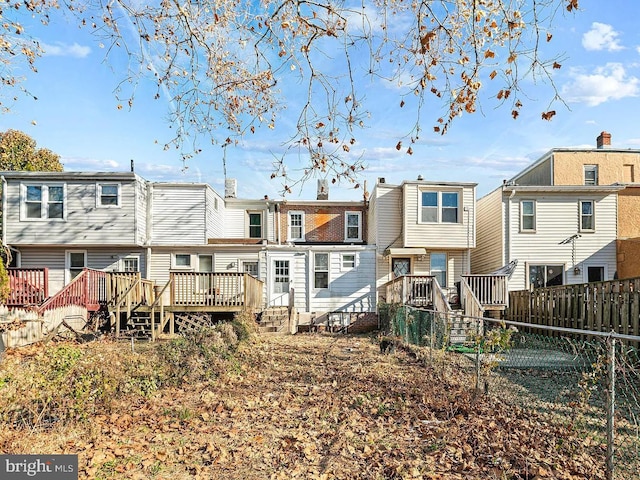 rear view of house featuring a deck, fence private yard, and a residential view