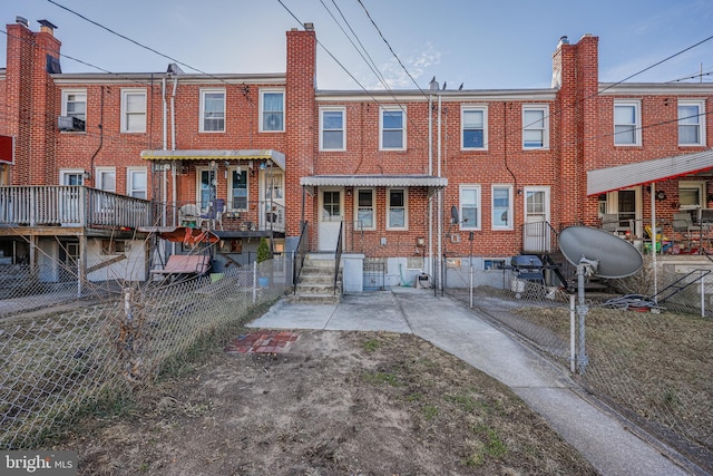 view of front of property with fence, brick siding, and a chimney