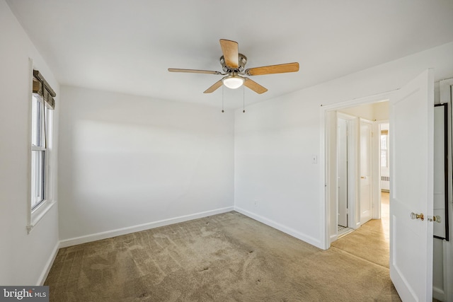 unfurnished room featuring baseboards, a ceiling fan, and carpet