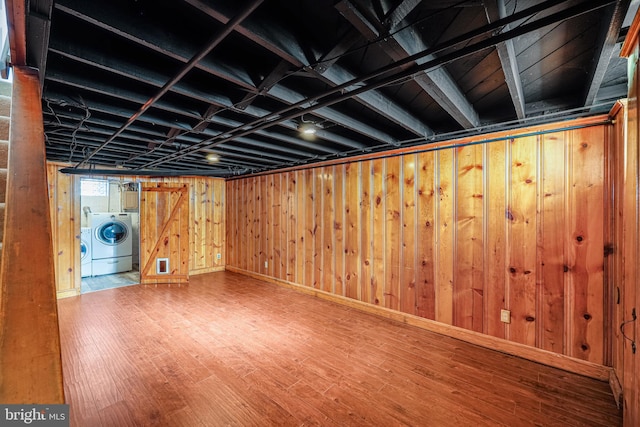 finished basement with wooden walls, independent washer and dryer, and wood finished floors