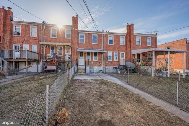 rear view of property with fence, brick siding, a chimney, and entry steps