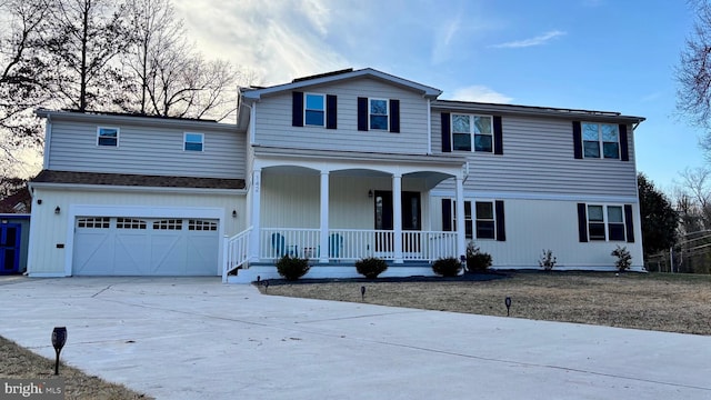 traditional-style house featuring covered porch, concrete driveway, and an attached garage