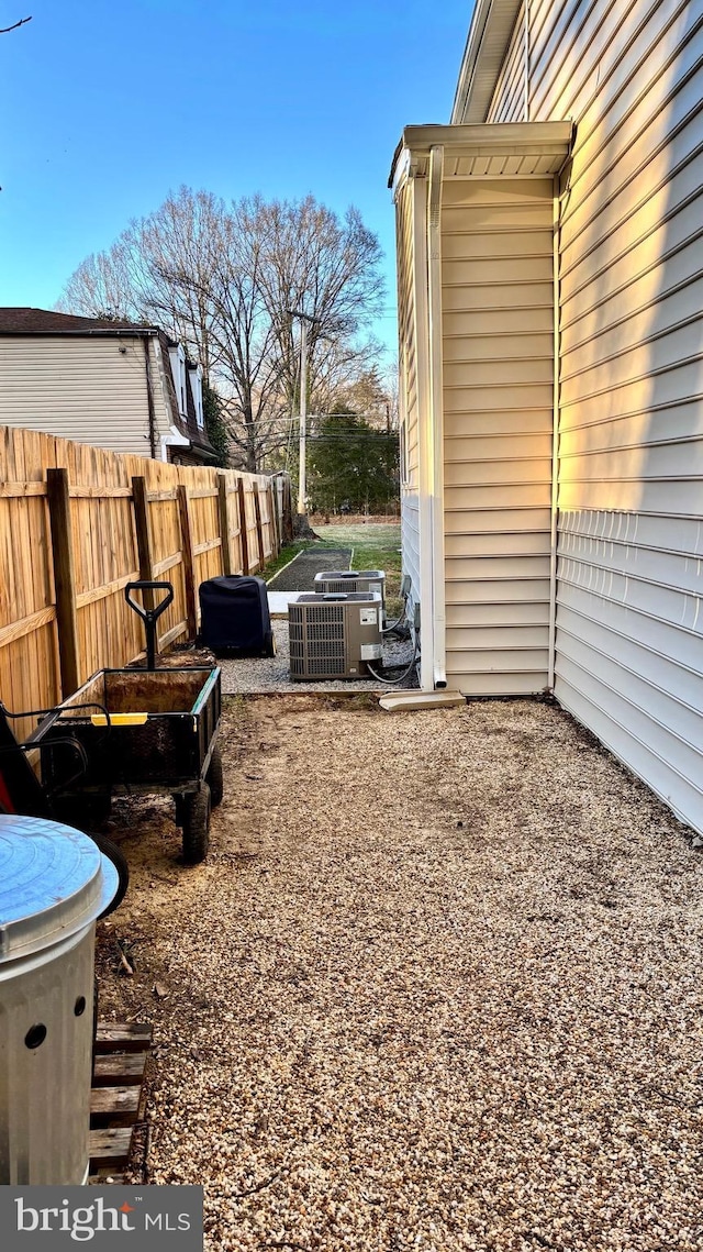 view of yard with central air condition unit and fence