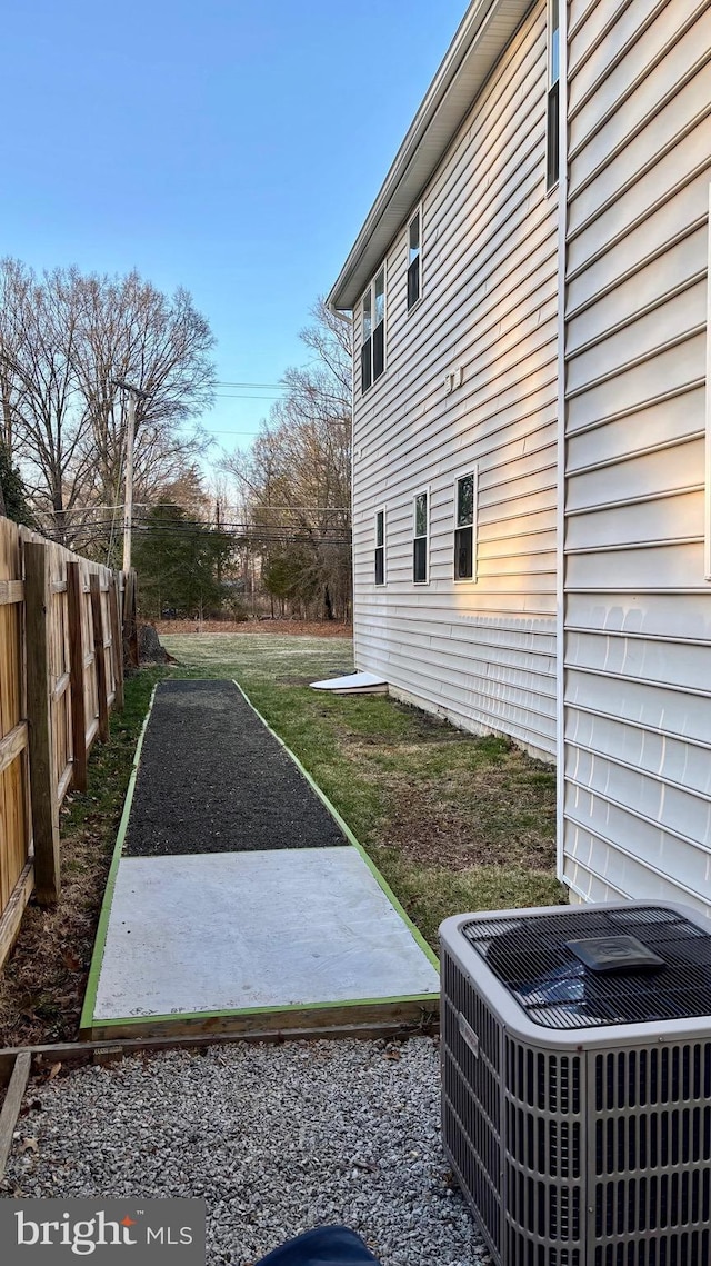 view of yard with a patio, fence, and central AC