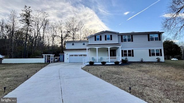 traditional home with a porch, a front yard, and driveway