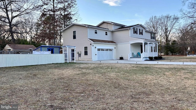 exterior space featuring driveway, a porch, fence, an attached garage, and a front yard