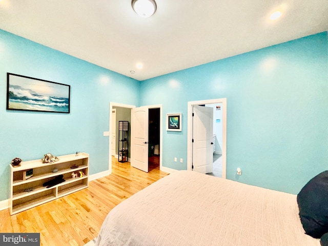 bedroom with recessed lighting, baseboards, and wood finished floors