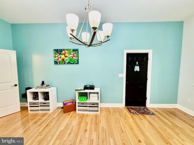 interior space with a notable chandelier, baseboards, and wood finished floors