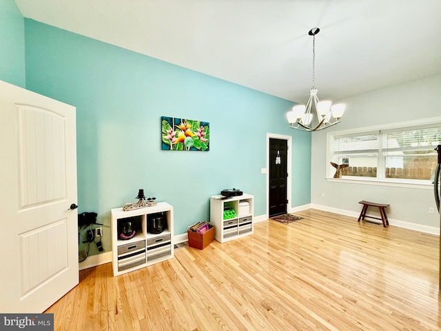 interior space featuring a chandelier, baseboards, and wood finished floors