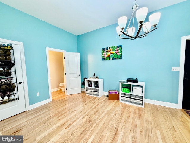 game room with an inviting chandelier, wood finished floors, and baseboards