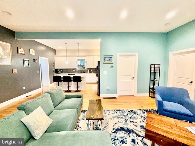 living area featuring recessed lighting, light wood-style flooring, and baseboards