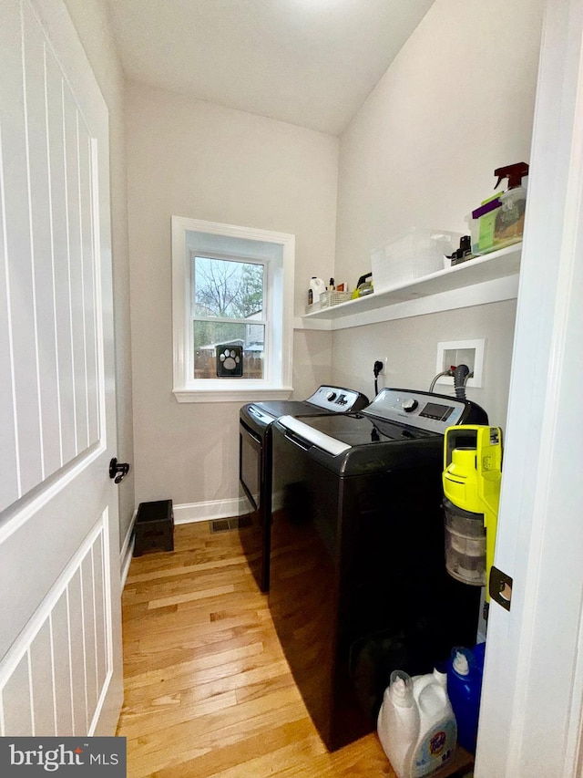 laundry area with visible vents, light wood-style flooring, separate washer and dryer, baseboards, and laundry area