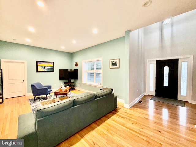 living room featuring recessed lighting, wood finished floors, and baseboards