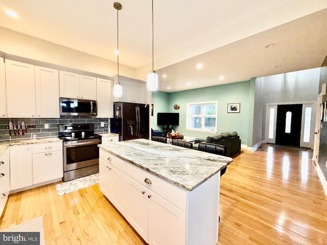 kitchen with tasteful backsplash, a center island, light wood-style floors, appliances with stainless steel finishes, and white cabinets