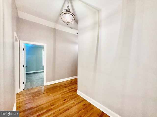 corridor featuring wood finished floors and baseboards