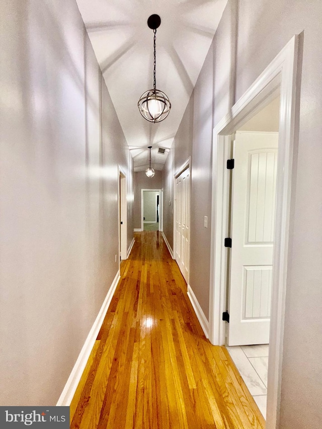 hall featuring light wood-type flooring and baseboards