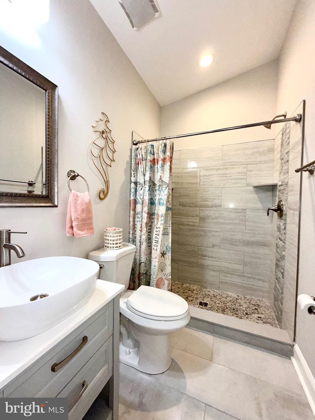 bathroom featuring visible vents, toilet, lofted ceiling, a tile shower, and vanity