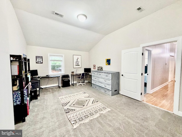 home office with visible vents, carpet flooring, and lofted ceiling