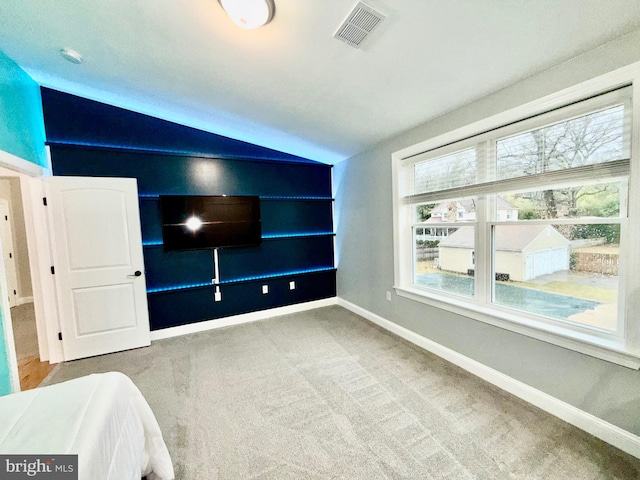 bedroom with lofted ceiling, carpet, visible vents, and baseboards