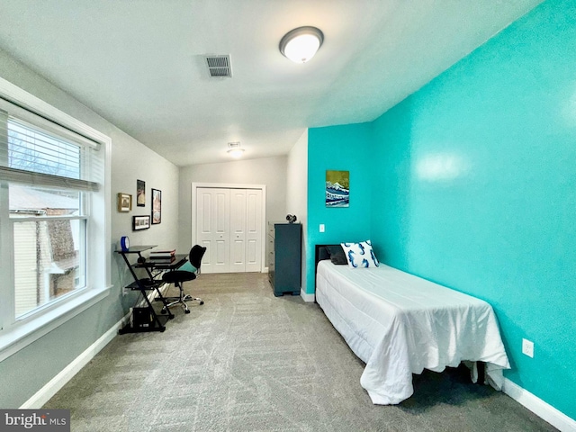 carpeted bedroom featuring lofted ceiling, baseboards, visible vents, and a closet