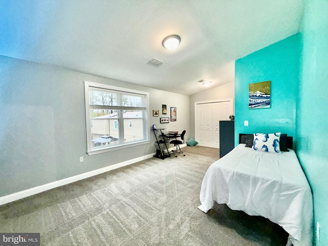 bedroom featuring visible vents, a closet, carpet, baseboards, and vaulted ceiling