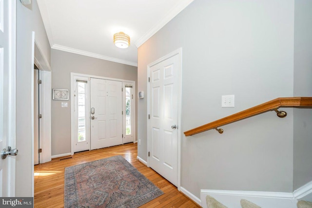 entrance foyer with light wood-type flooring, crown molding, and baseboards