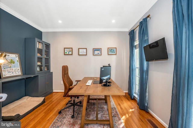 office area with light wood-style flooring, ornamental molding, and baseboards