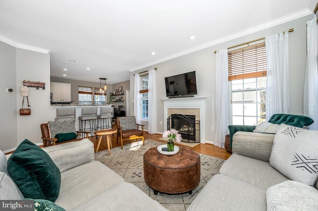 living room with plenty of natural light, ornamental molding, baseboards, and recessed lighting